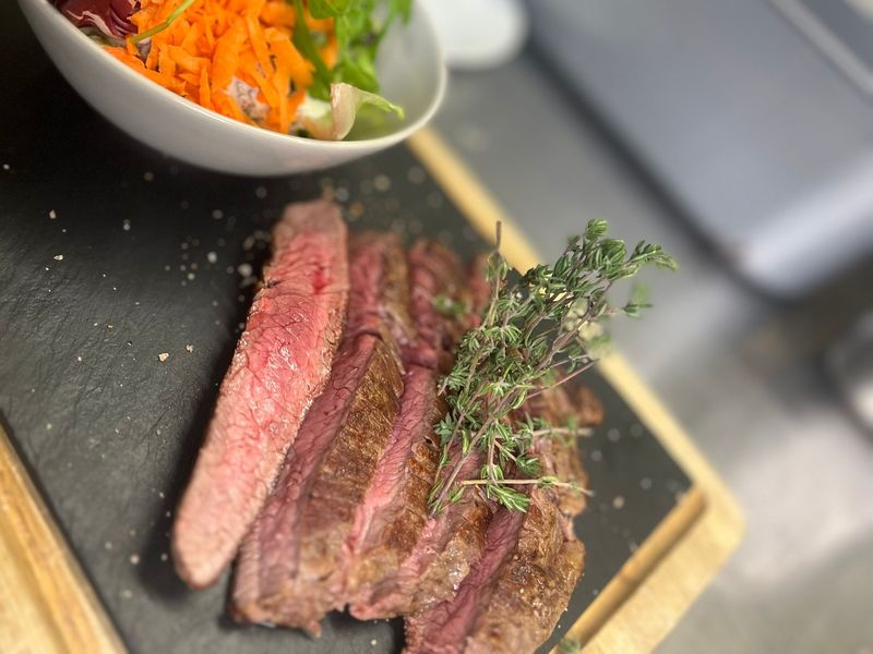 Aufgeschnittenes Steak mit Thymian auf Schieferplatte